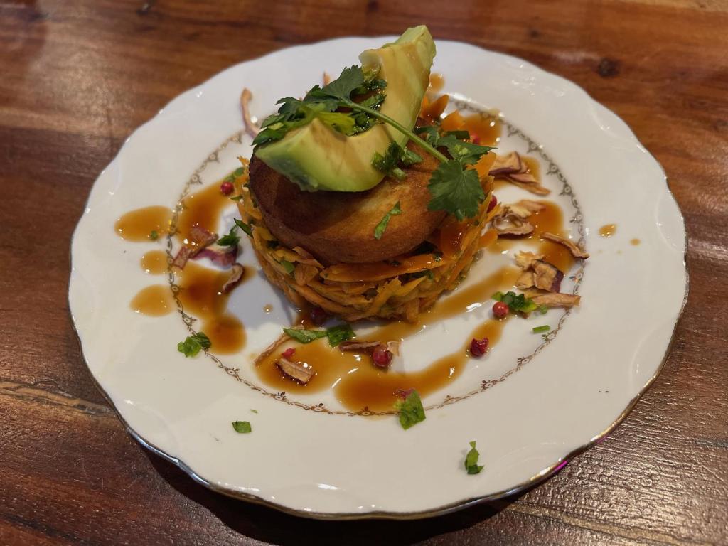 a plate of food with an avocado on a table at Maison LGBT des Monts Bleus in Saint-Roman-de-Tousque