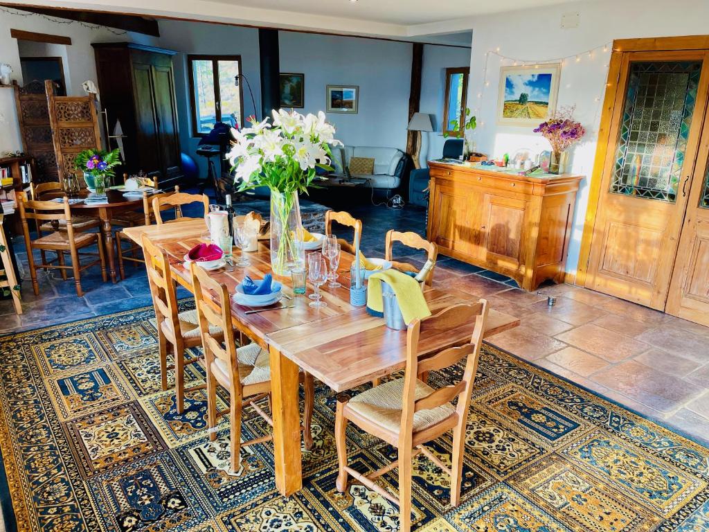 a dining room with a wooden table and chairs at Maison LGBT des Monts Bleus in Saint-Roman-de-Tousque