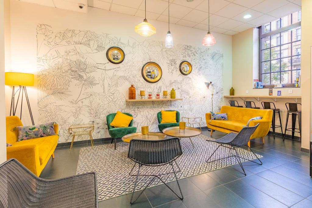 une salle d'attente avec des tables et des chaises jaunes et vertes dans l'établissement Appart'City Confort Strasbourg Centre, à Strasbourg