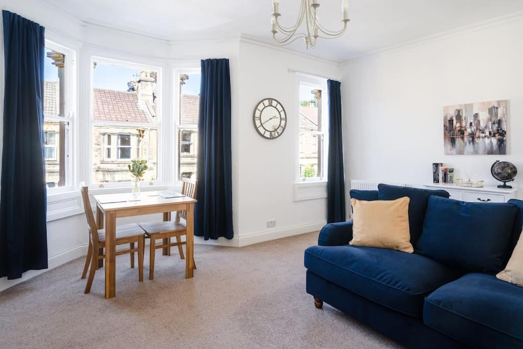 a living room with a blue couch and a table at Central Bath apartment in Bath