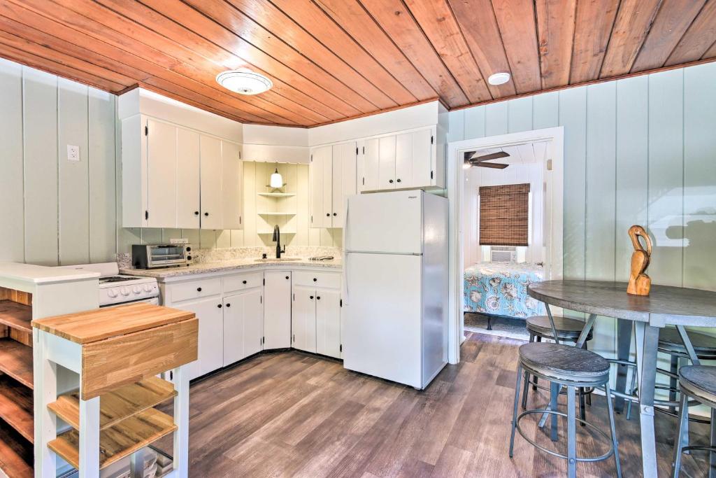 een keuken met een witte koelkast en een tafel bij Siesta Key Couples Escape - Walk to Beaches! in Sarasota