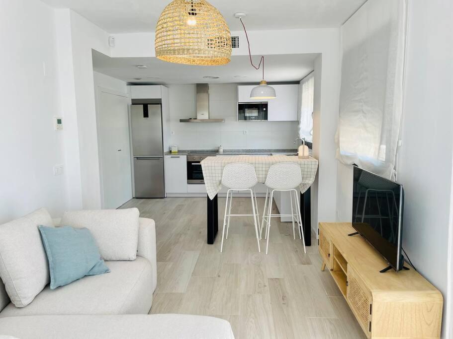un soggiorno con divano e tavolo e una cucina di Apartment- Roques Daurades Residential a L'Ametlla de Mar
