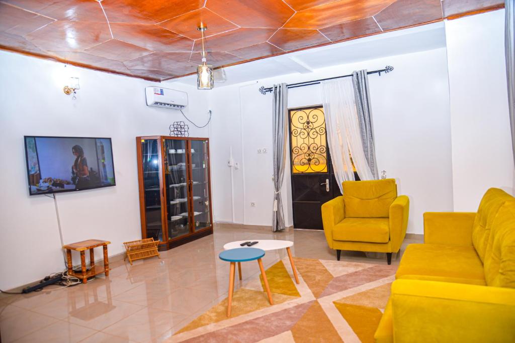 a living room with a couch and chairs and a table at Appartement meublé 2 chambres avec salle de bain - 1 salon - 1e cuisine - La Concorde - Quartier Nkomkana in Yaoundé