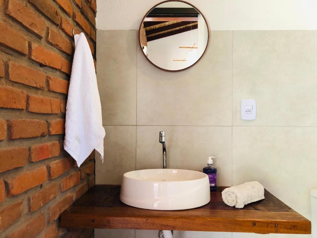 uma casa de banho com um lavatório e uma parede de tijolos em Aruanã - Praia do Sargi em Serra Grande