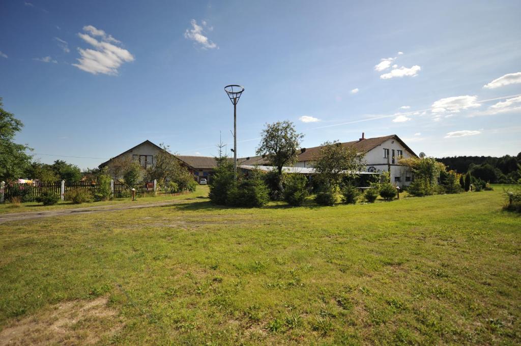 un gran patio con casas y un campo de césped en Agroturystyka Kociewiak en Szteklin
