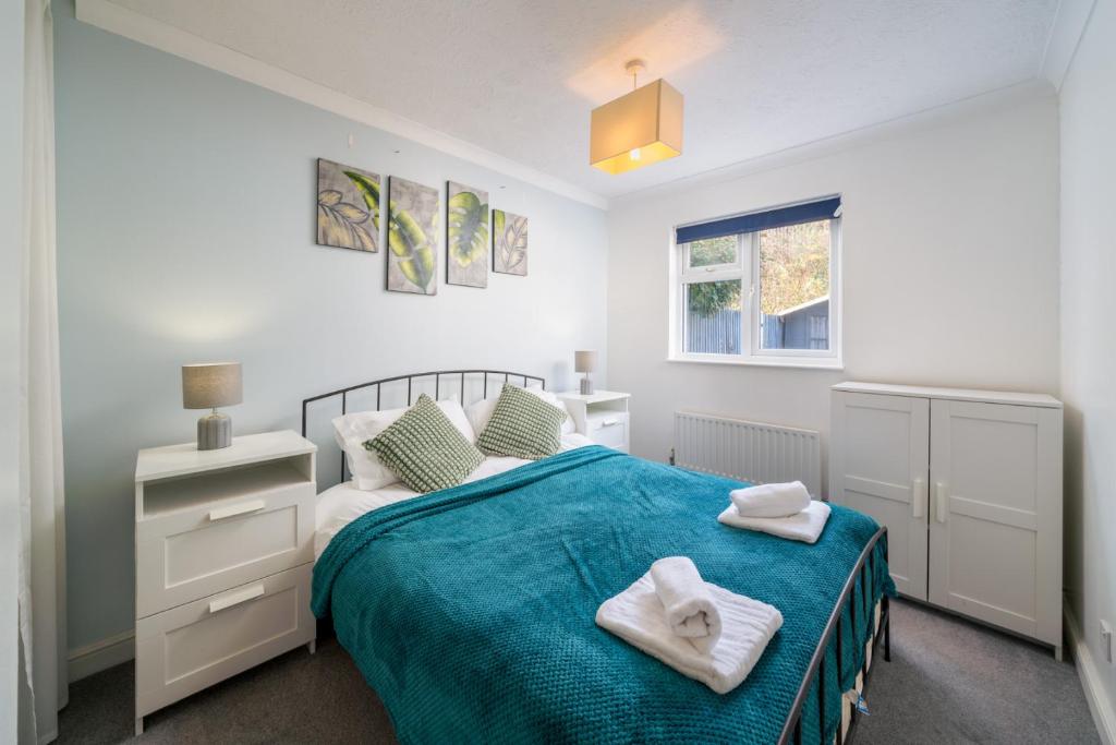 Crawley 1-Bedroom Pet Friendly Apartment في Three Bridges: غرفة نوم عليها سرير وفوط
