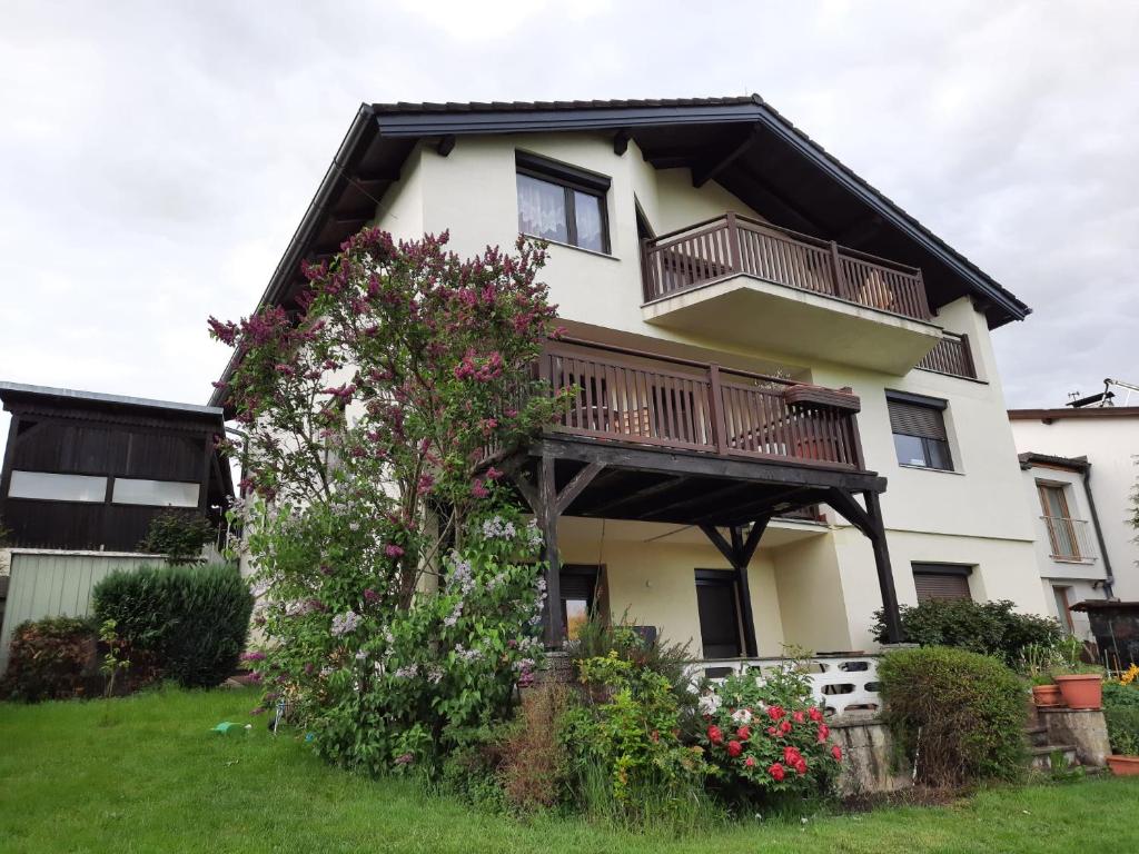 una casa con balcone e fiori nel cortile di Erholungsheim im Wienerwald a Irenental