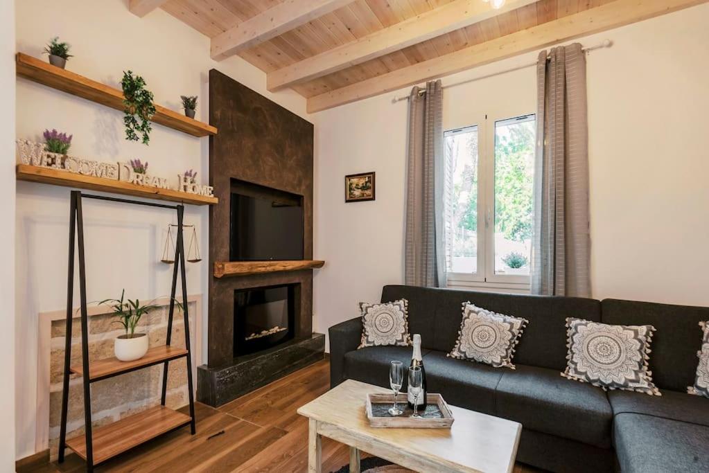 ein Wohnzimmer mit einem Sofa und einem Kamin in der Unterkunft Myrovolos luxury Angie's house in Ialyssos