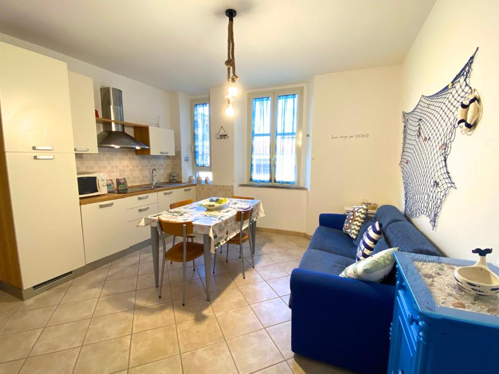 sala de estar con sofá azul y cocina en Appartamento Bucaniere en San Vincenzo