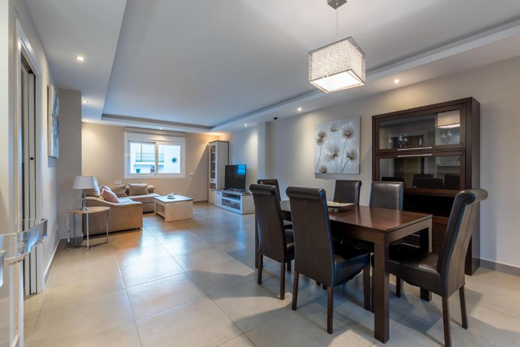 a dining room and living room with a table and chairs at Chalet Tiro del Pichón I in Marbella