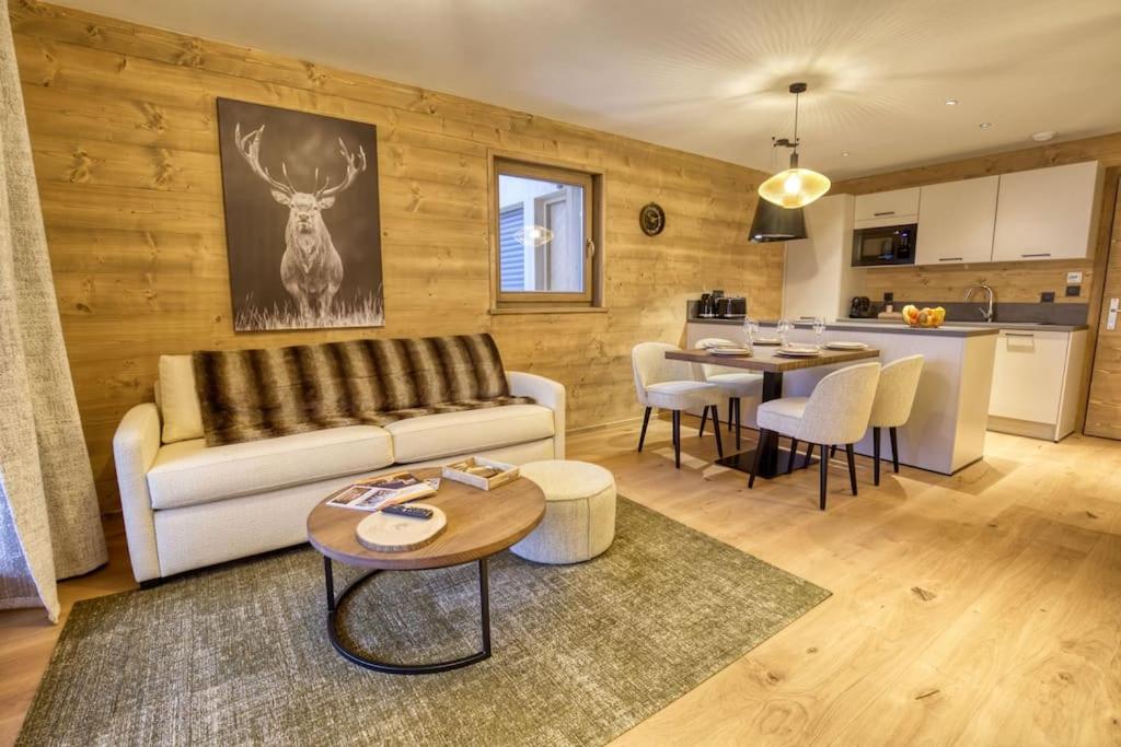 uma sala de estar com um sofá e uma mesa em Magnifique appartement dans luxueux chalet - ARAVIS em Crest-Voland
