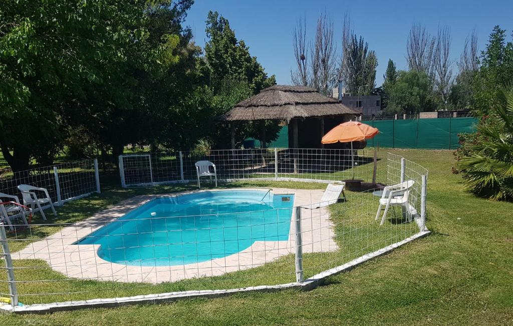 a swimming pool in a yard with a gazebo at Posada y Cabañas "Finca El Rincón de Lunlunta" in Mendoza