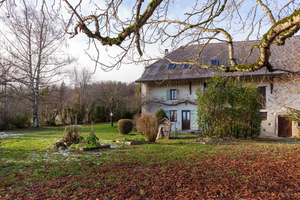 een oud huis in een veld met een tuin bij La Ferme du Bonheur - Un cocon d'authenticité au cœur de la nature in Cruseilles