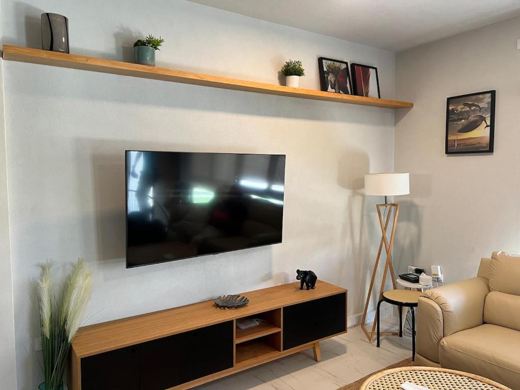 Casa con alberca en Residencial Portovela في نويفو فايارتا: غرفة معيشة مع تلفزيون بشاشة مسطحة على جدار