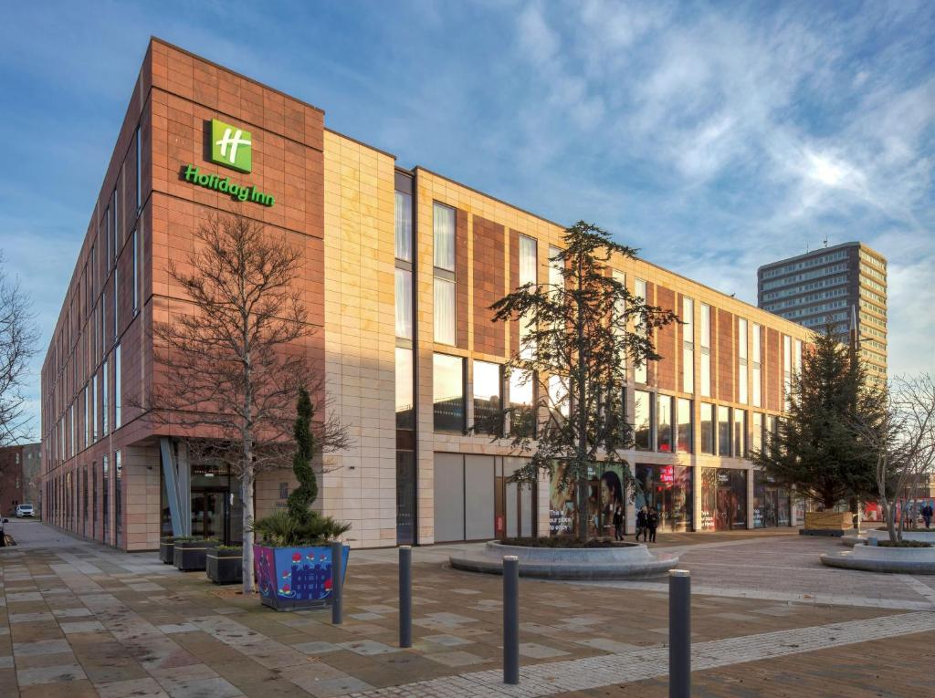 un gran edificio de ladrillo con un letrero de farmacia. en Holiday Inn Sunderland - City Centre, an IHG Hotel en Sunderland