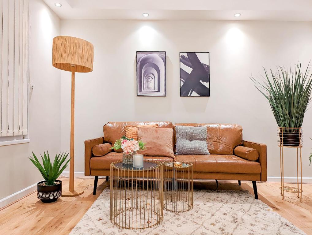 un soggiorno con divano marrone e tavolo di 1BD apartment in Leyton zone 2 a Londra