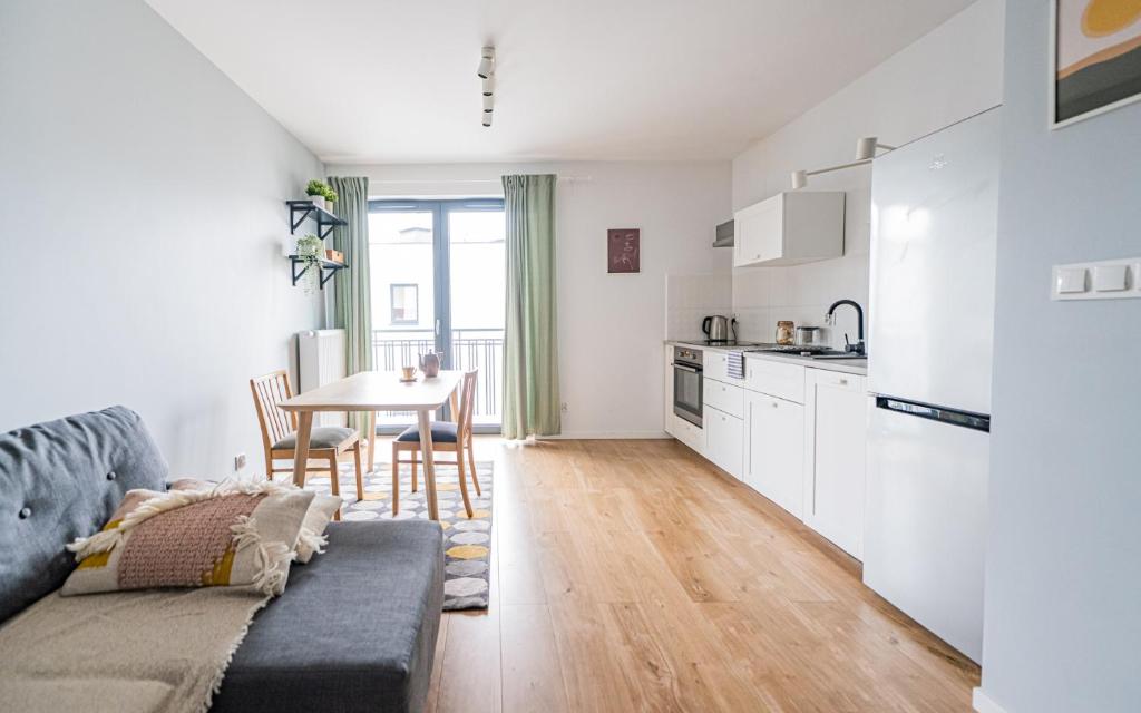 a kitchen and living room with a couch and a table at POLAKA Apartment ~ Self Check-In 24 ~ Car Park ~Lift in Wrocław