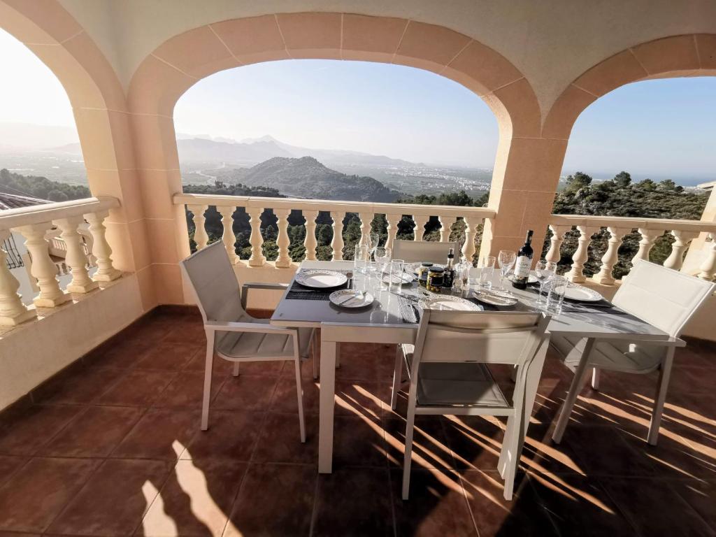 - une salle à manger avec une table, des chaises et des fenêtres dans l'établissement Self contained, detached hillside Villa near Oliva with stunning vistas, à Castillo del Reboller