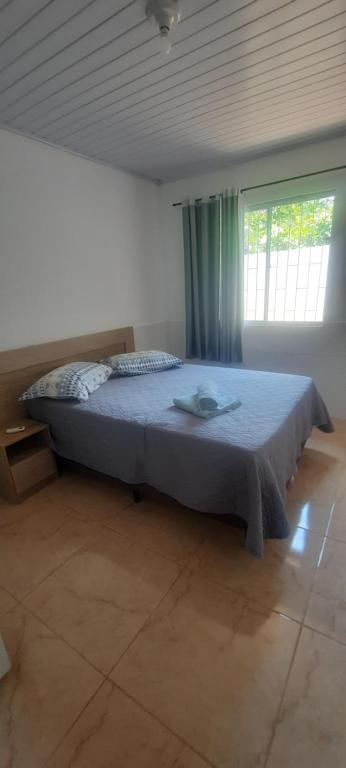 1 dormitorio con 1 cama en una habitación con ventana en Casa FLORIANÓPOLIS, Praia de PONTA DAS CANAS,1, en Florianópolis