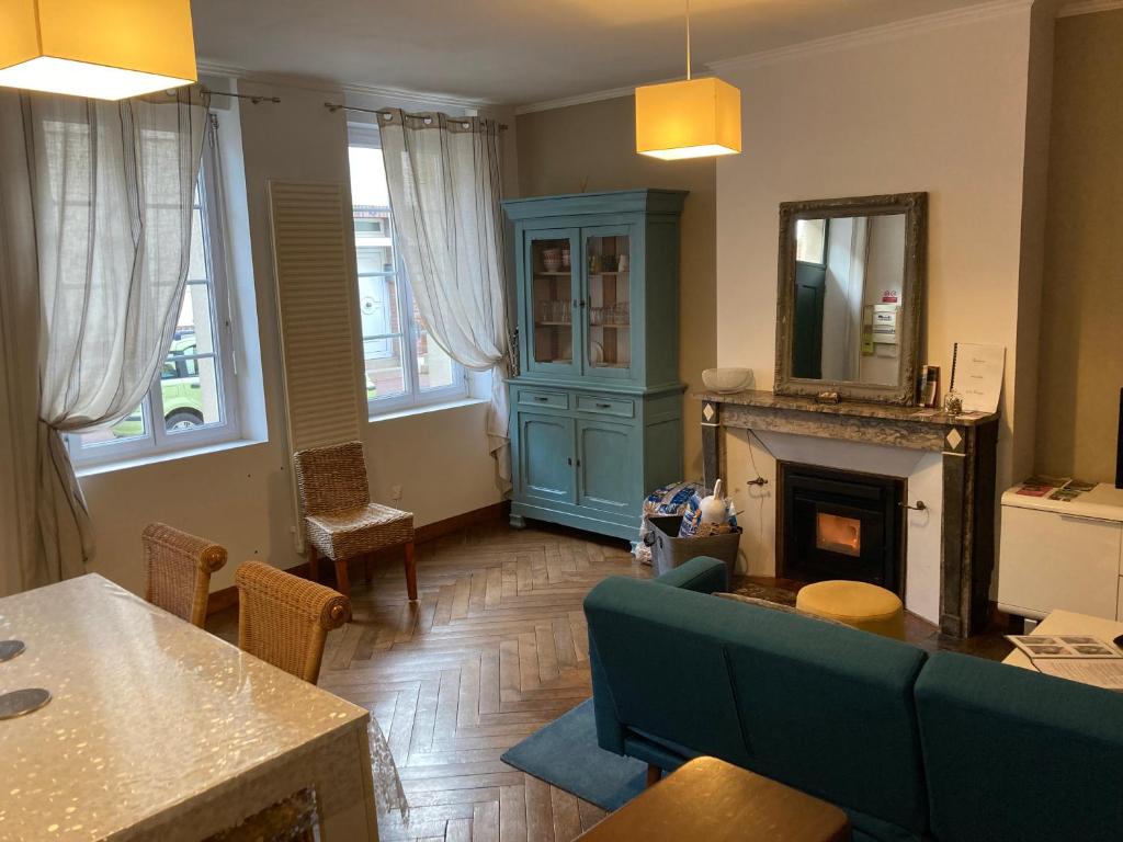 a living room with a couch and a fireplace at Le Logis de Pélagie in Neufchâtel-en-Bray