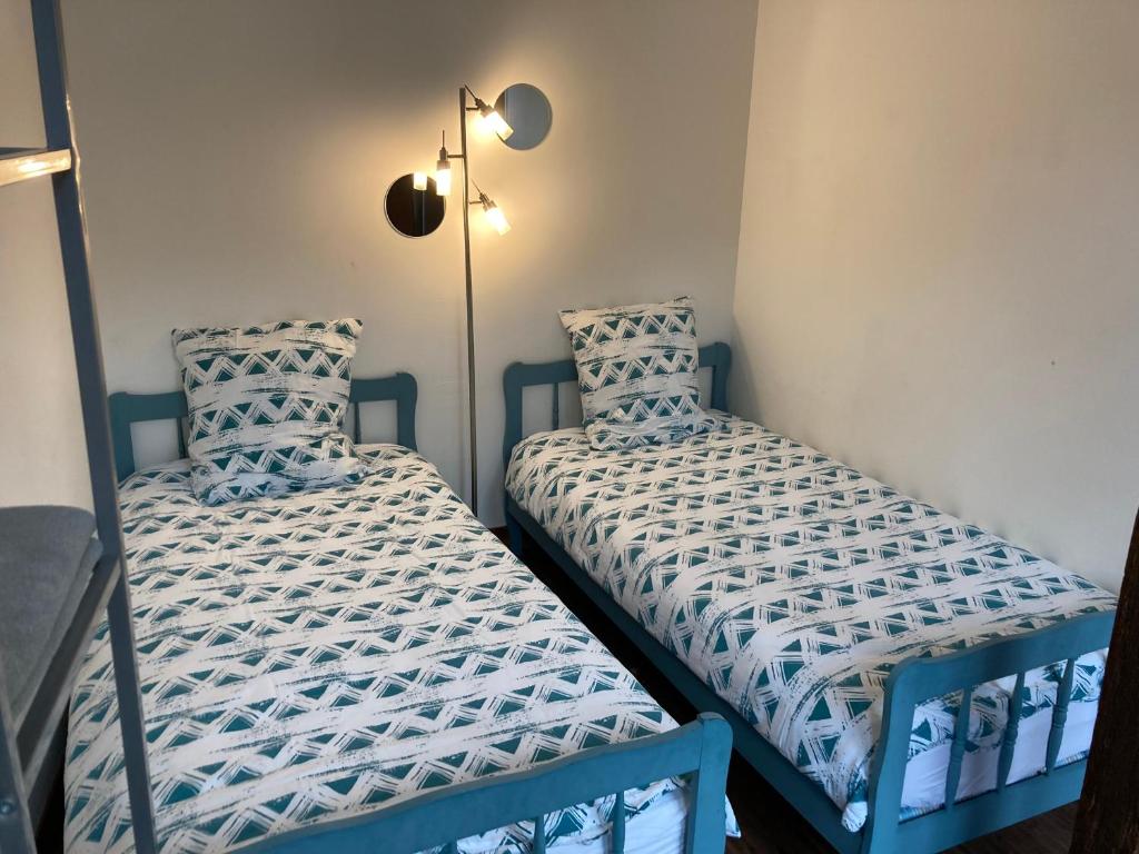 two beds sitting next to each other in a room at Le Logis de Pélagie in Neufchâtel-en-Bray