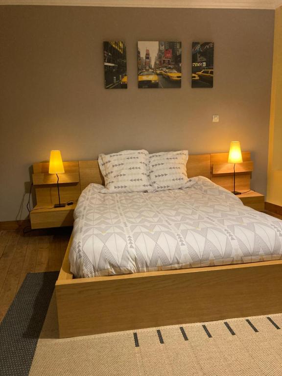 a bedroom with a bed with two lamps on it at Le Logis de Pélagie in Neufchâtel-en-Bray