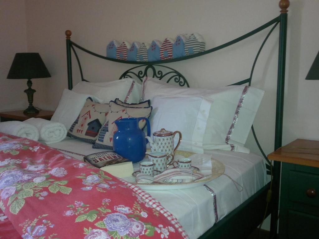 łóżko z niebieską wazą i talerzami w obiekcie Aguda Beachfront Apartment w mieście Aguda