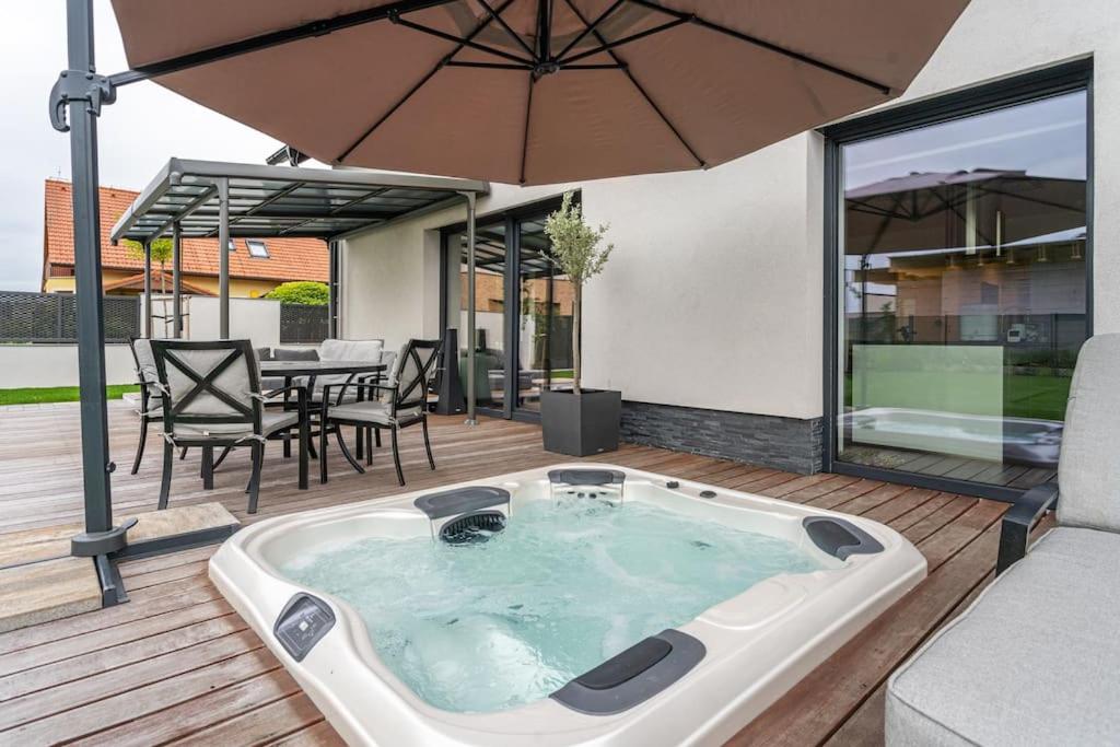 a hot tub on a deck with an umbrella at ESCAPE THE ORDINARY (Sauna & Jacuzzi) in Jesenice