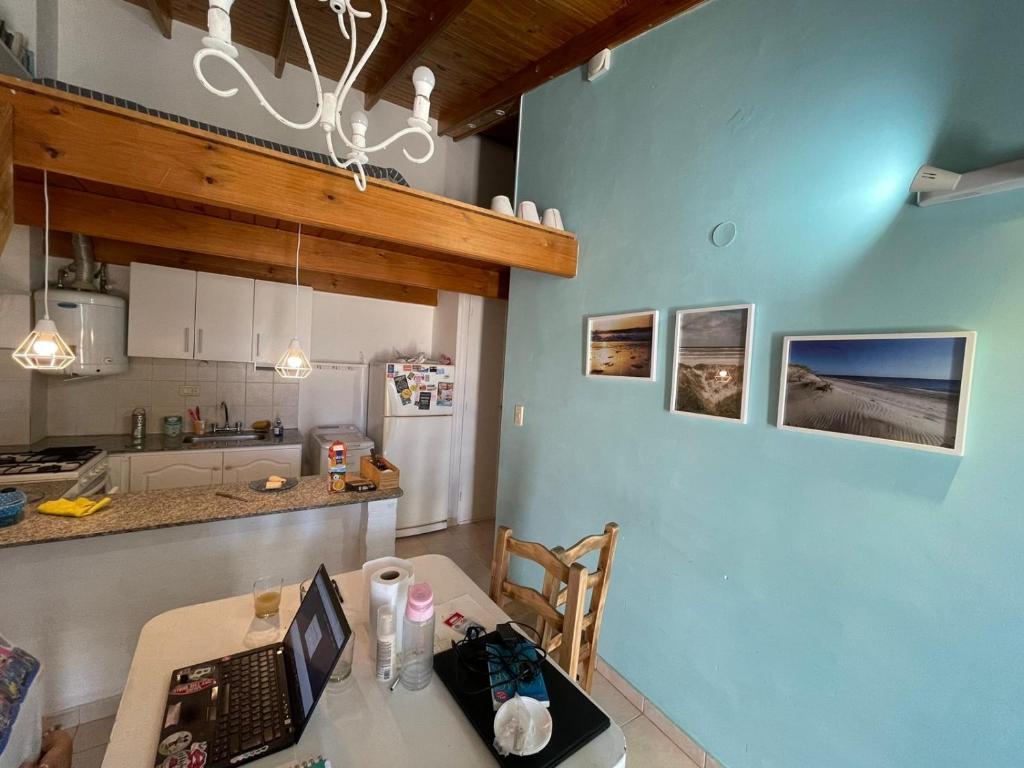 een keuken met een tafel met daarop een laptop bij Alojamiento PISCIS in Puerto Madryn