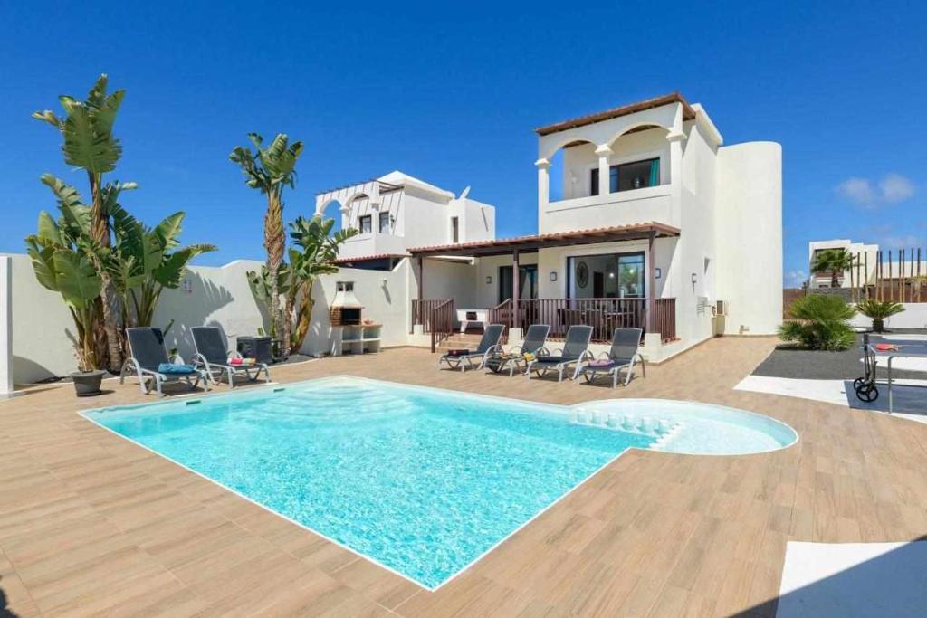 a villa with a swimming pool in front of a house at Villa Aguamarina in Playa Blanca