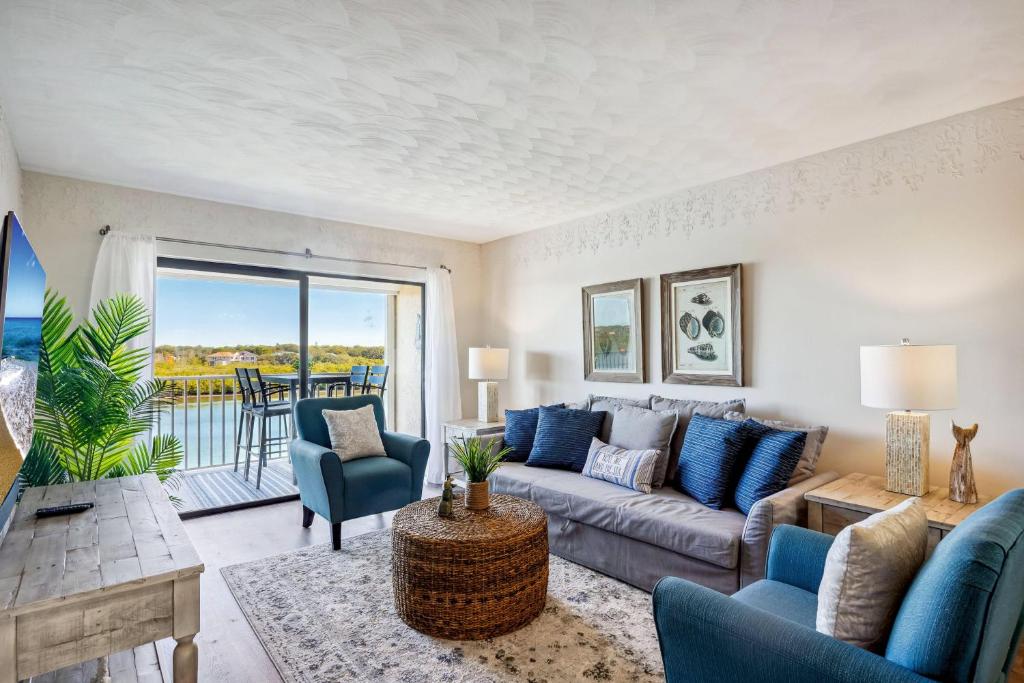 sala de estar con sofá y sillas y balcón en Bayshore Yacht & Tennis 409 - Premier, en Clearwater Beach