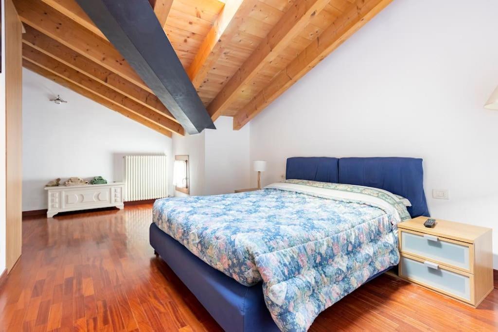 a bedroom with a blue bed and a wooden floor at PARCO ROMY - Free Parking con giardino in Limena