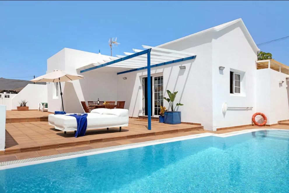 une villa avec un lit et une piscine dans l'établissement Villa Turqué, à Arrieta