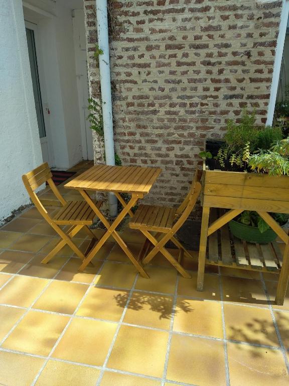 a wooden table and two chairs on a patio at Les Gîtes d&#39;Angres - gîte n°1 in Angres