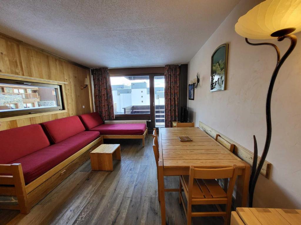 a living room with a red couch and a table at Appartement Tignes, 2 pièces, 5 personnes - FR-1-449-23 in Tignes