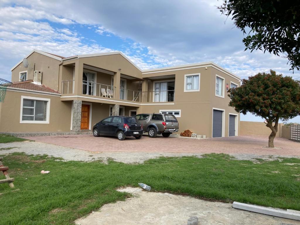a house with two cars parked in front of it at Elim Rest Place in Fisherhaven