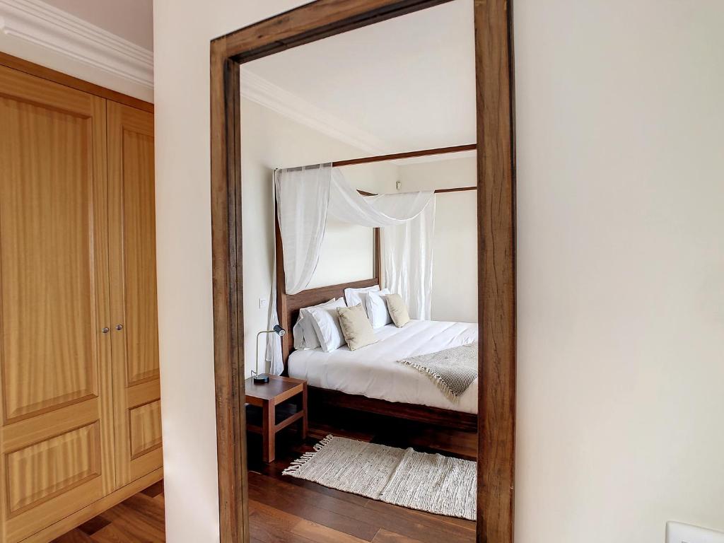 einem Spiegel, der ein Schlafzimmer mit einem Bett reflektiert in der Unterkunft Ocean 59 by LovelyStay in Funchal