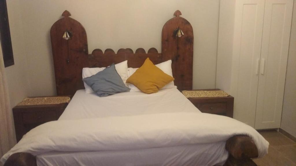 ミグダルにあるצימר יאירのベッド(木製のヘッドボード、枕付)