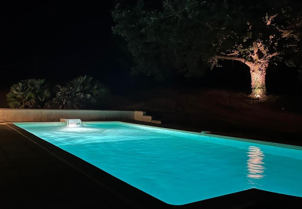 a swimming pool lit up at night at Maison Lamothe in Flamarens