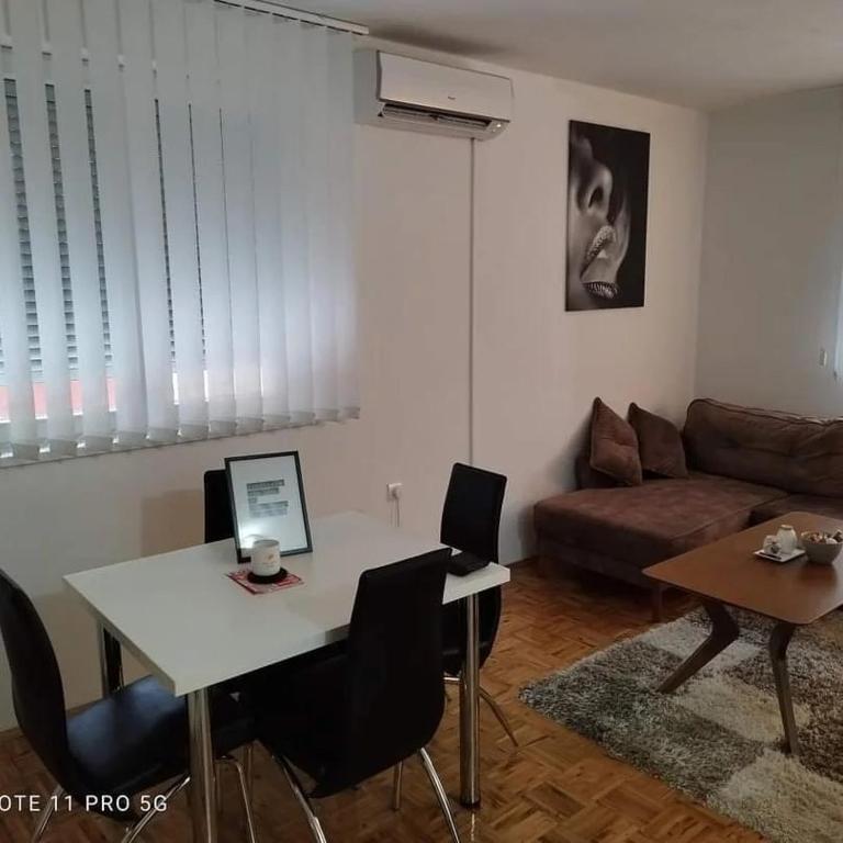 een woonkamer met een witte tafel en een bank bij Apartman Kosta in Vrnjačka Banja