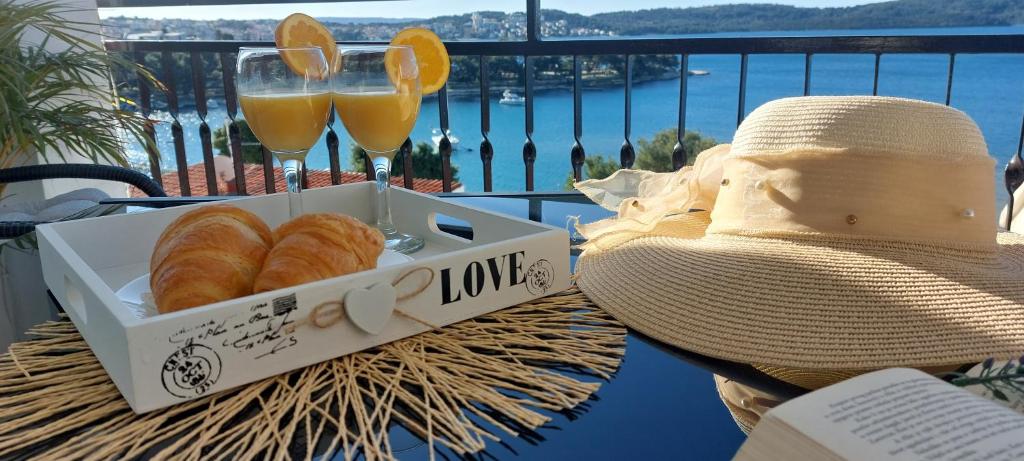 einen Tisch mit einer Schachtel Croissants und zwei Gläsern Orangensaft in der Unterkunft Apartment Kristina in Trogir
