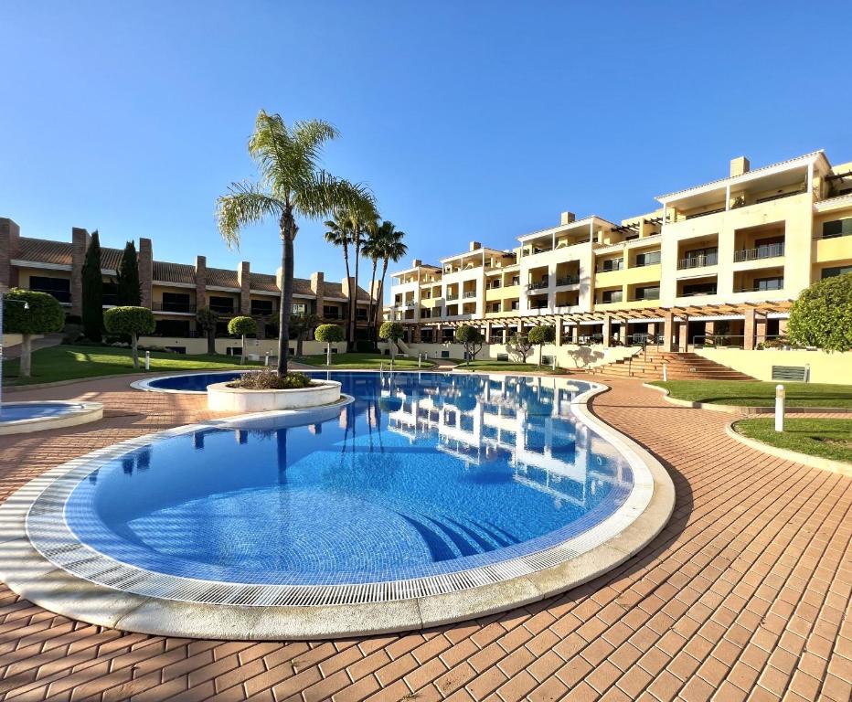 uma piscina em frente a um resort em Olivos del golf - Terrace with pool by HD em Vilamoura