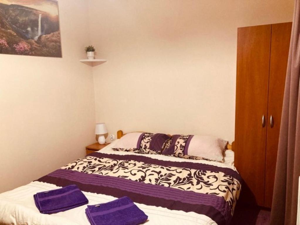 Dworek Ewunia في فيسلا: غرفة نوم بسريرين عليها مناشف ارجوانية
