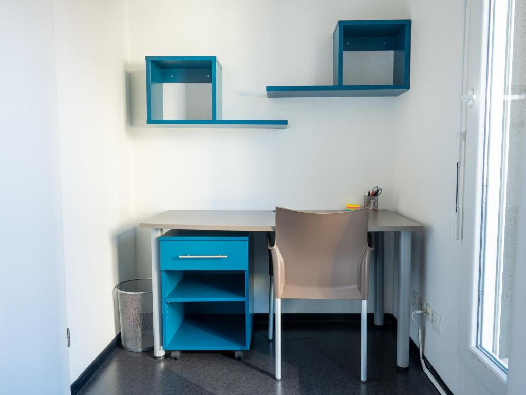 a desk with a chair and a blue cabinet at Le Stratège in Marseille