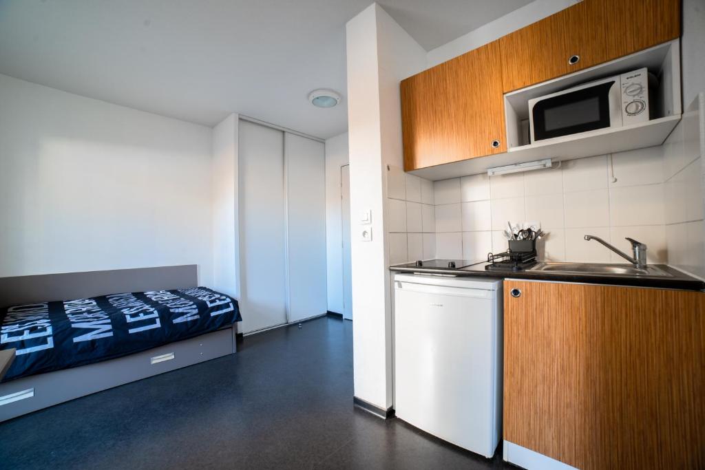 a kitchen with a sink and a bed in a room at Le Stratège in Marseille