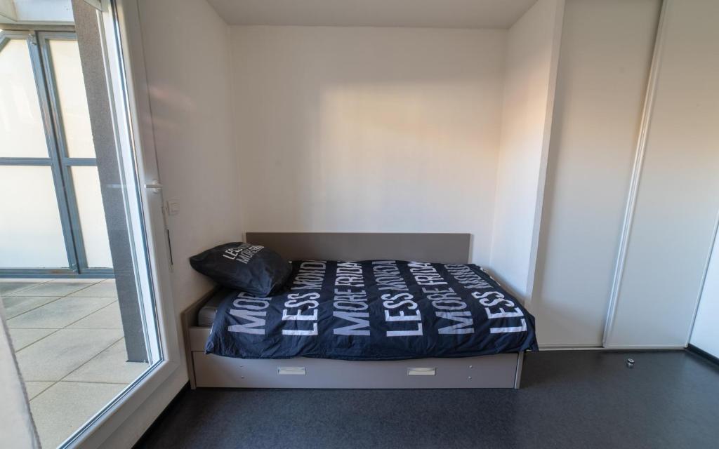 a small bed in a room with a window at Le Stratège in Marseille