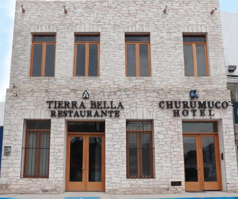 un bâtiment en briques blanches avec un panneau sur celui-ci dans l'établissement HOTEL CHURUMUCO, à San José Iturbide