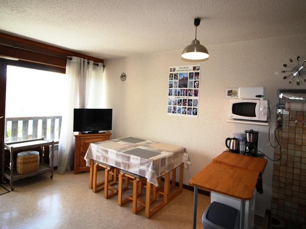- une cuisine avec une table et un four micro-ondes dans l'établissement Studio cabine 4 personnes au pied des pistes avec balcon et parking - Auris en Oisans - FR-1-297-282, à Auris