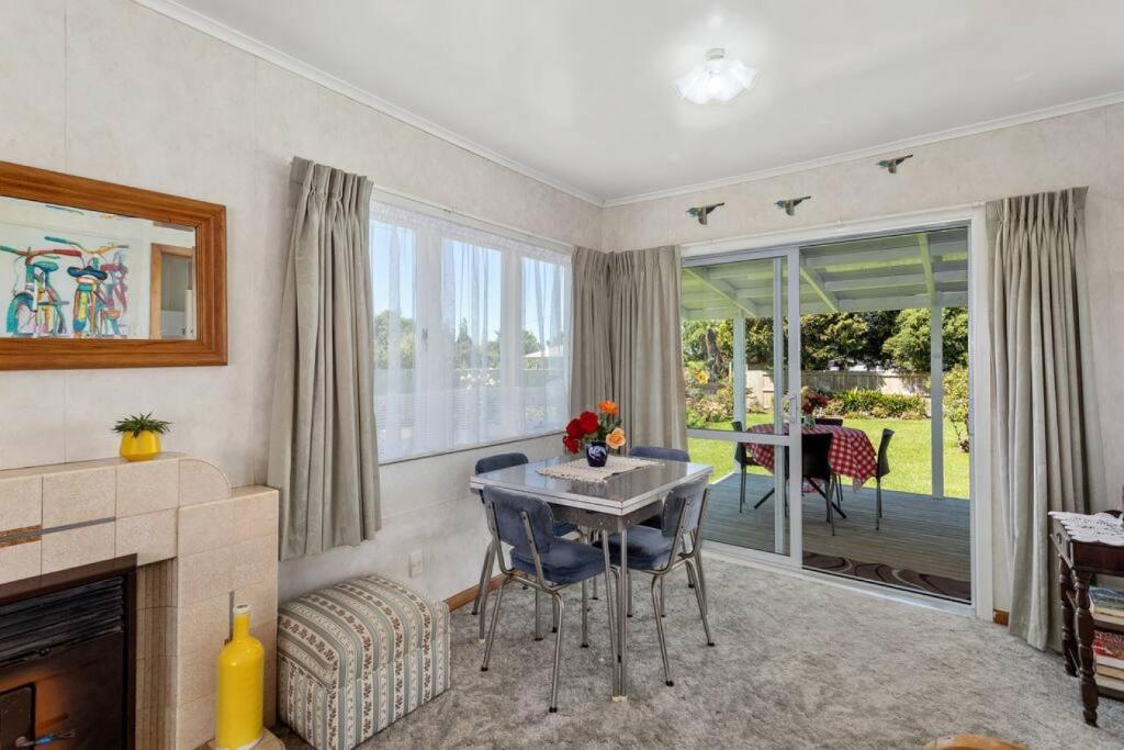 a living room with a table and a fireplace at Retro Cottage in Opotiki CBD in Opotiki