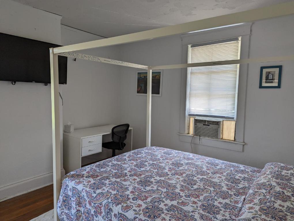 1 dormitorio con cama, escritorio y ventana en Historic UVA Apartment - near the corner en Charlottesville